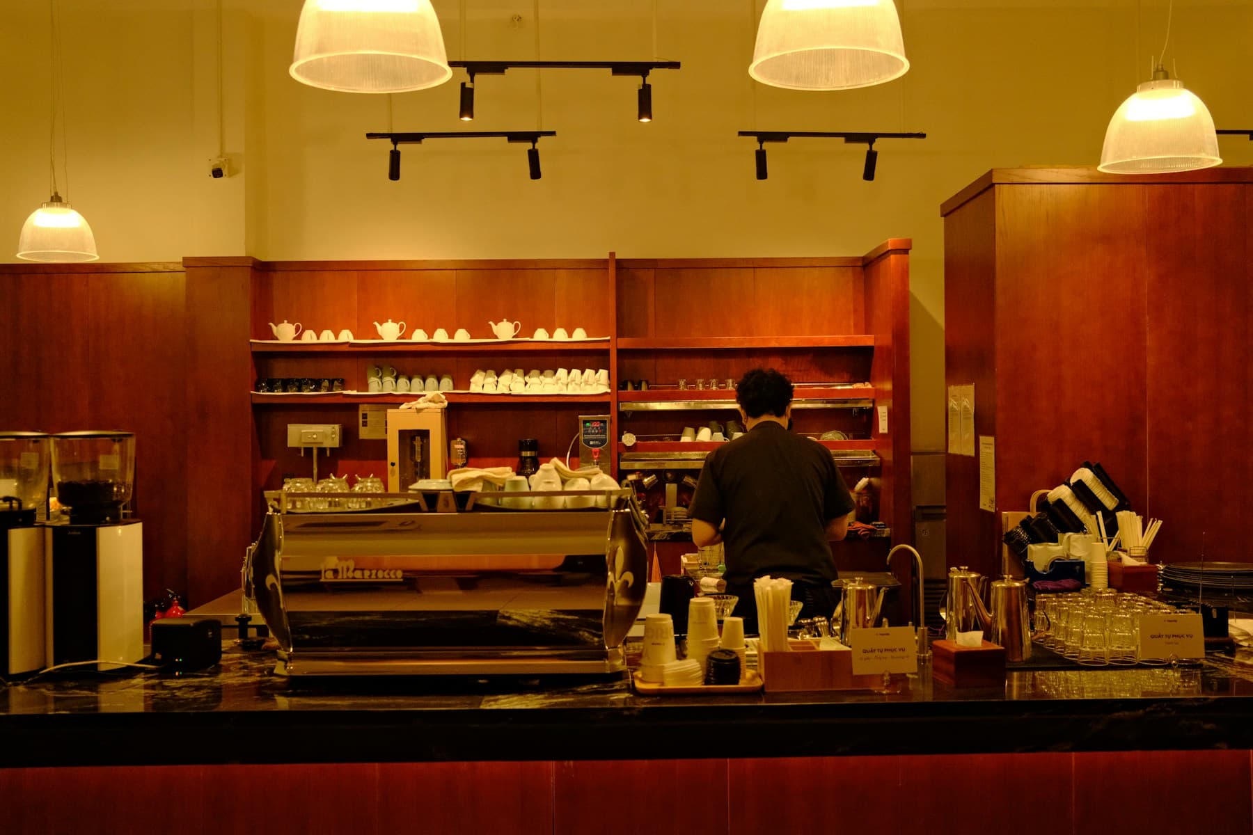 A barista at work in a warm, light-filled independent café